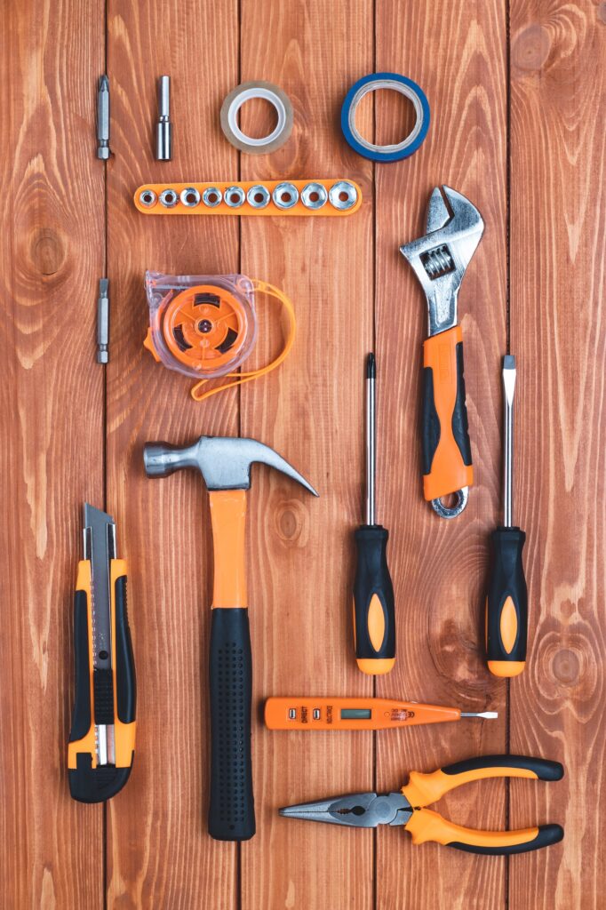Set of construction tools on a brown wooden background. Hammer, wrench